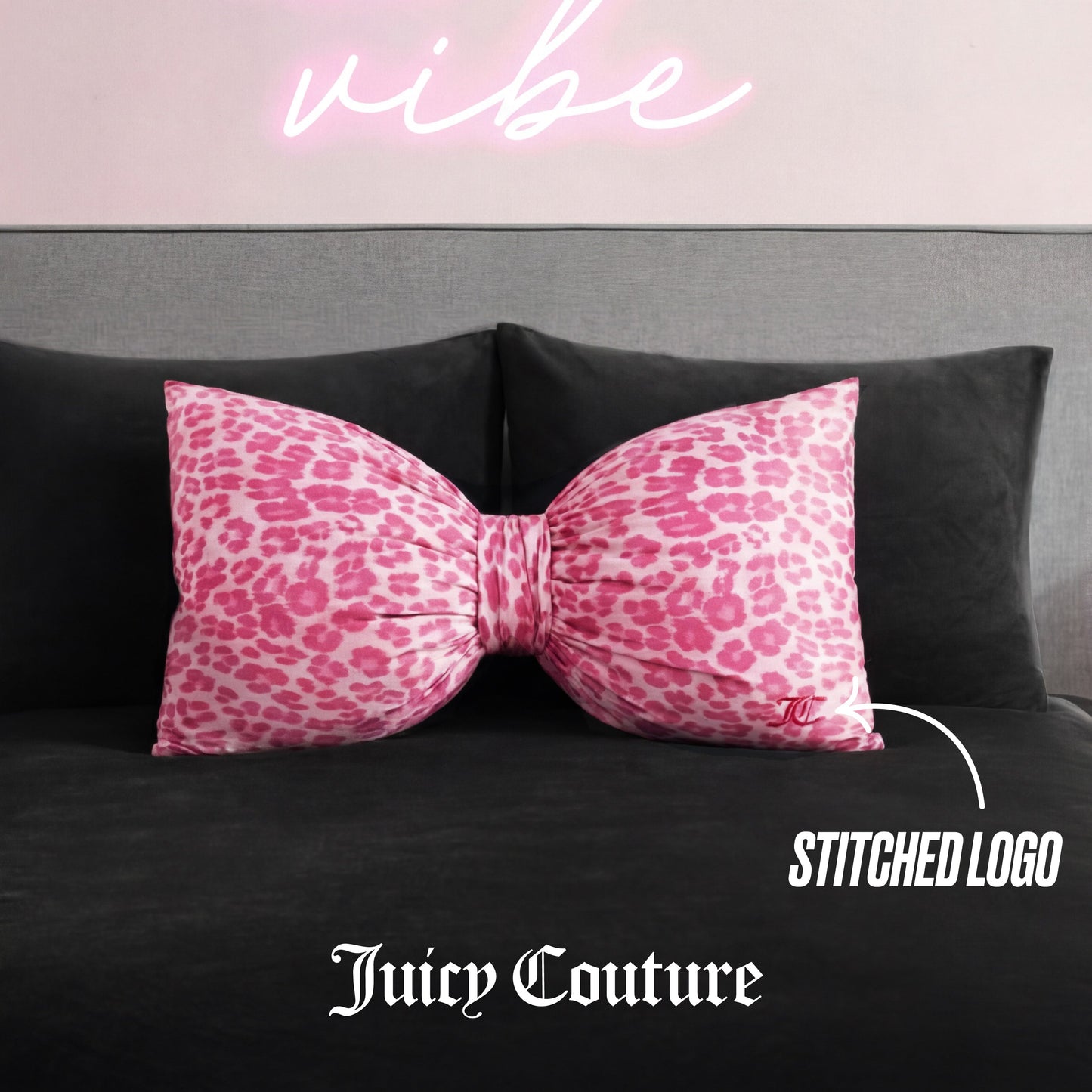 A Bow Decorative Pillow with pink cheetah print and a stitched Juicy Couture logo rests on a dark gray couch, with "vibe" in pink neon above and text highlighting the logo.