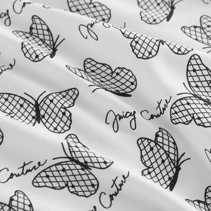 The Microfiber Sheet Set With Extra Pillowcases features a white luxury fabric with a net-like black butterfly pattern and repeated Juicy Couture cursive, adding style to your bedding.