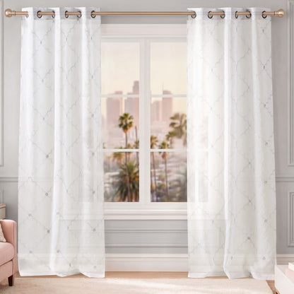 Scallop Diamond Sheer Window Curtains with a grommet header hang gracefully on a gold curtain rod in front of the window, featuring a subtle pattern that allows glimpses of the cityscape and palm trees outside.