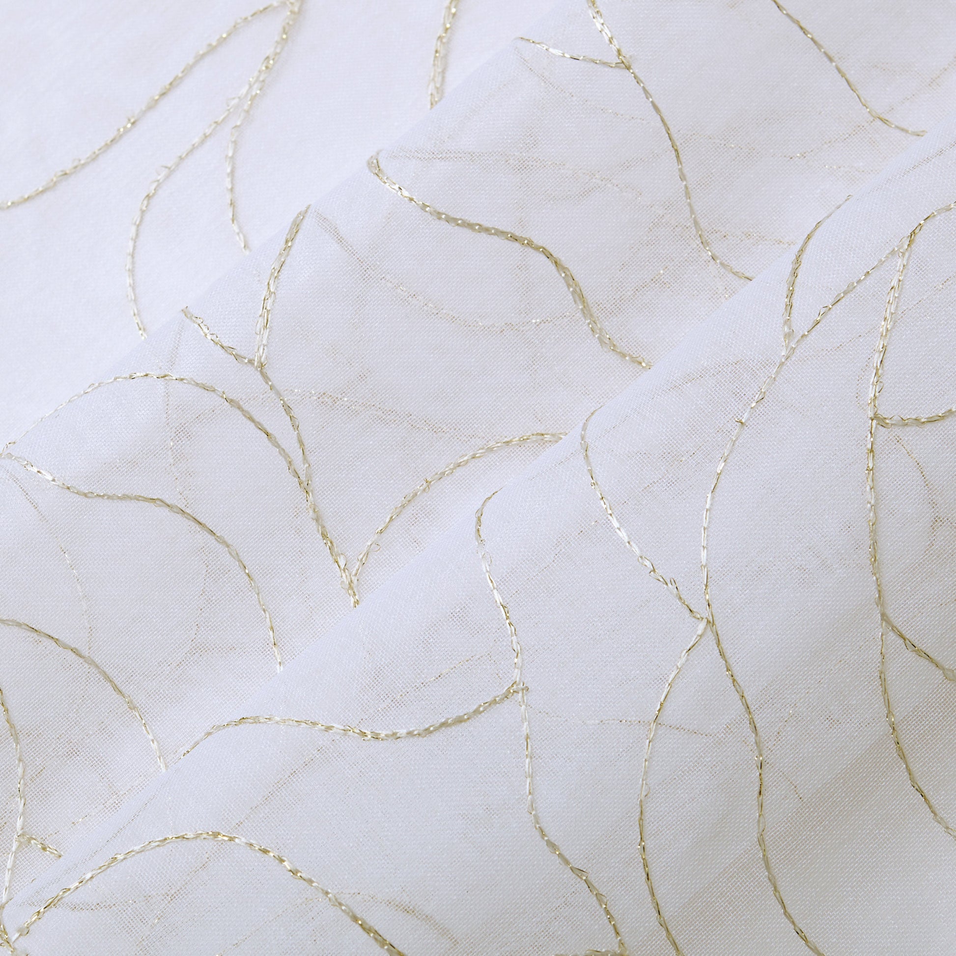 Rose Swirl Sheer Window Curtains feature white fabric adorned with delicate, curved gold lines forming an abstract, wavy pattern. The slightly raised lines add texture and an elegant, decorative touch to the smooth surface, making these curtains perfect for a grommet header style that blends sophistication with modern appeal.