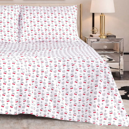 The Microfiber Sheet Set With Extra Pillowcases, featuring a subtle red and black cherry pattern, is paired with a mirrored nightstand topped with a lamp and decorative accents to create a modern bedroom setting enhanced by luxury bedding for superior comfort and style.