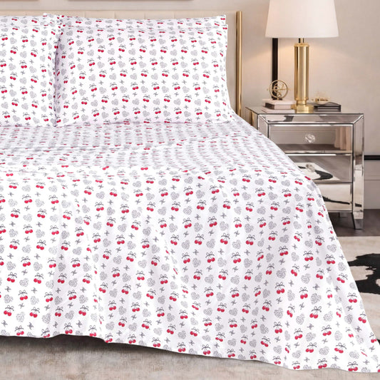 The Microfiber Sheet Set With Extra Pillowcases, featuring a subtle red and black cherry pattern, is paired with a mirrored nightstand topped with a lamp and decorative accents to create a modern bedroom setting enhanced by luxury bedding for superior comfort and style.