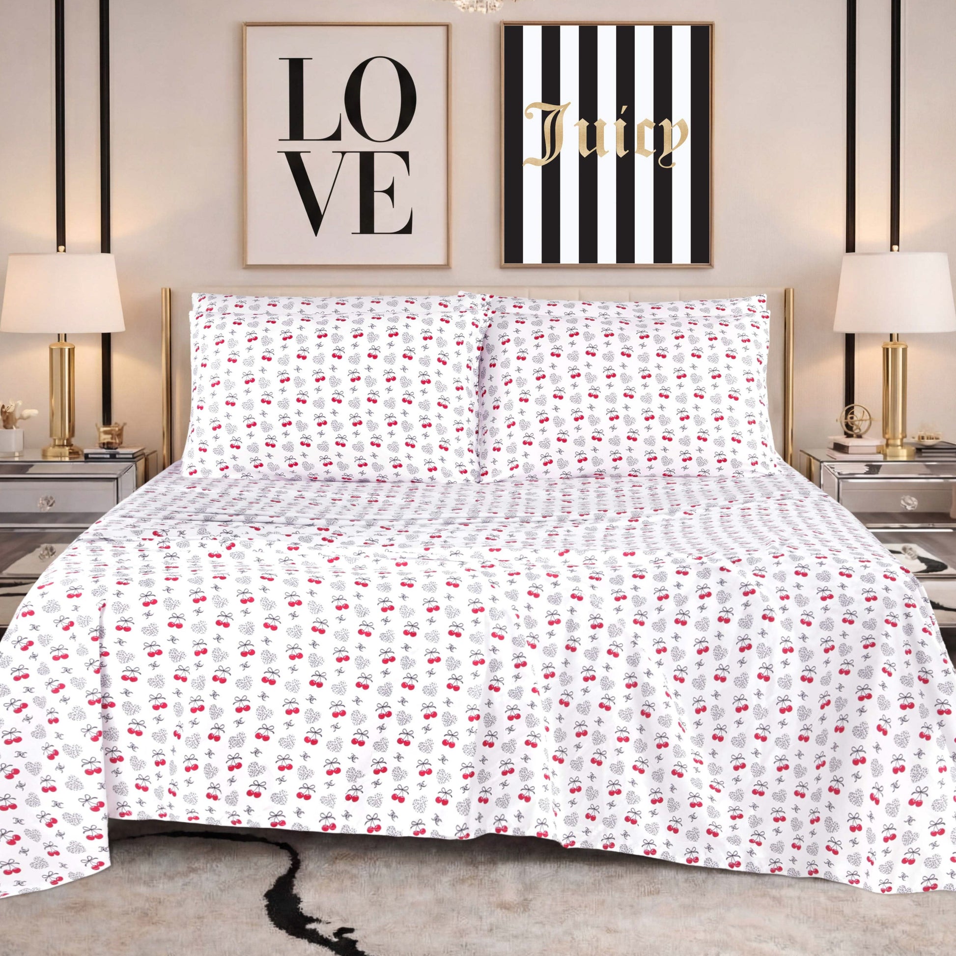 A bed dressed in the Microfiber Sheet Set With Extra Pillowcases, featuring white sheets with a red and black rose pattern, is flanked by two nightstands topped with lamps. Above the bed hang two wall art pieces: one that reads "LOVE" and another that says "Juicy" on black and white stripes.