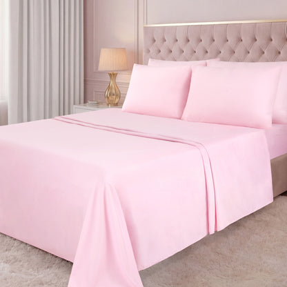 A neatly made bed with a light pink Microfiber Sheet Set With Extra Pillowcases, a tufted beige headboard, a white nightstand with a gold lamp, light curtains, and a white shaggy rug in a softly lit bedroom create an inviting atmosphere of luxury bedding.