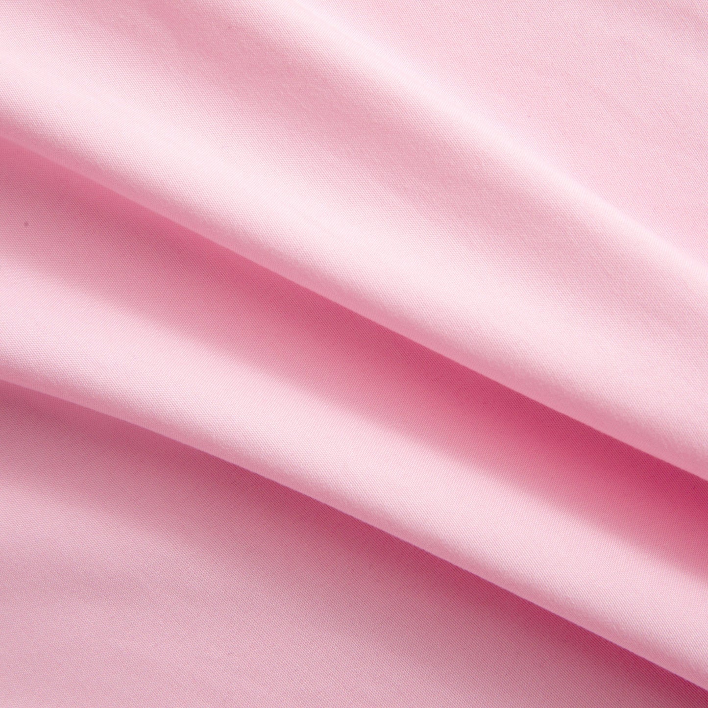 Close-up of soft pink microfiber fabric from the Microfiber Sheet Set With Extra Pillowcases, featuring gentle folds and a smooth texture that evoke the feel of luxury bedding, with light and shadow highlighting its elegant surface.
