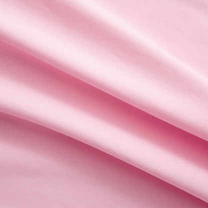 Close-up of soft pink microfiber fabric from the Microfiber Sheet Set With Extra Pillowcases, featuring gentle folds and a smooth texture that evoke the feel of luxury bedding, with light and shadow highlighting its elegant surface.