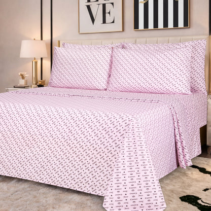A neatly made bed featuring the Microfiber Sheet Set With Extra Pillowcases in a pink patterned luxury design, adorned with two large pillows, complemented by a bedside lamp and framed artwork above the headboard in a cozy, modern bedroom.