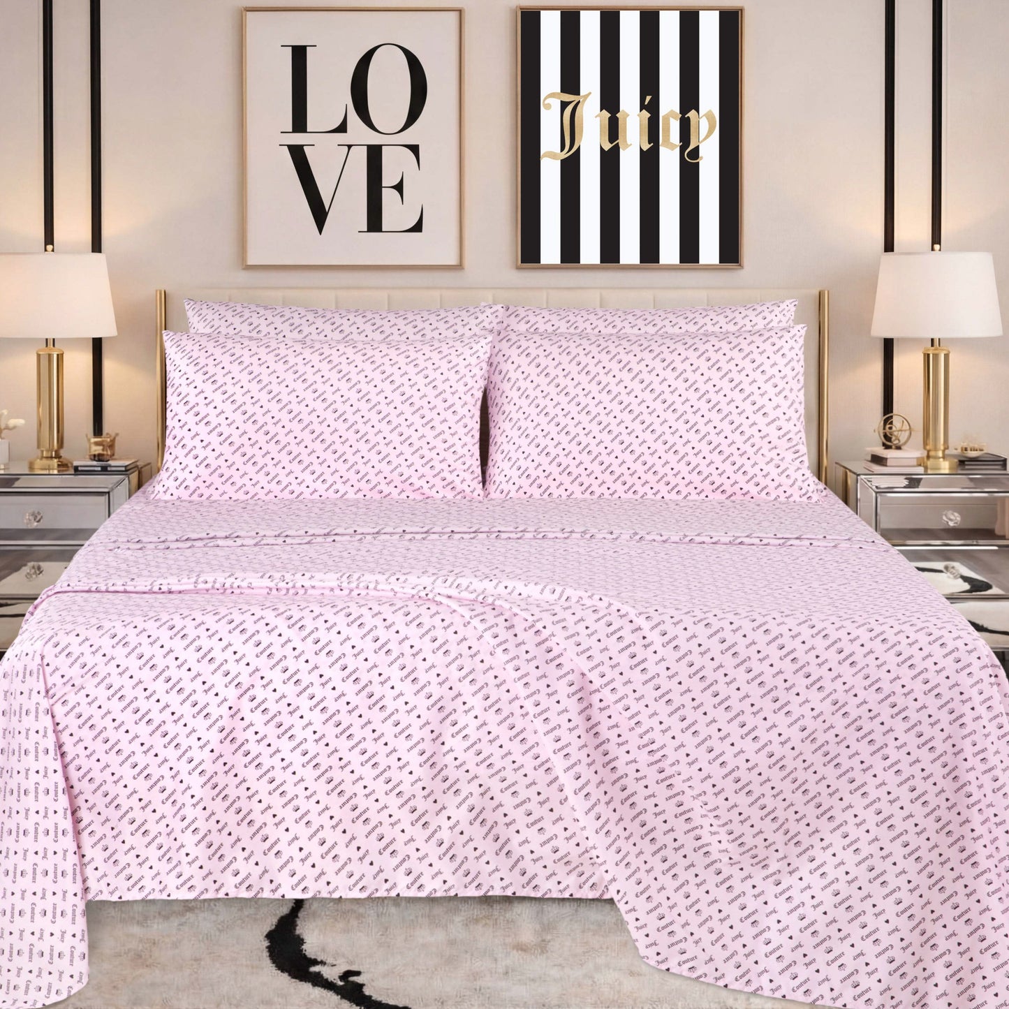 A neatly made bed with pink patterned bedding, featuring a Microfiber Sheet Set With Extra Pillowcases for added style, is flanked by two lamps on mirrored nightstands. Above the bed are two wall art pieces: one says LOVE and the other says Juicy on black and white stripes.