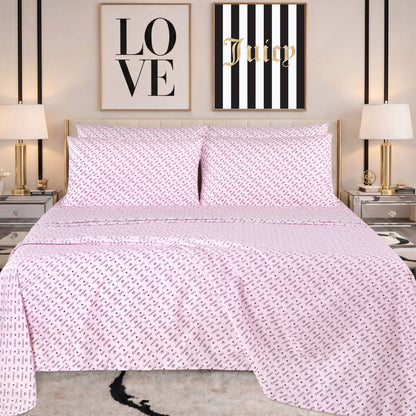 A neatly made bed with pink patterned bedding, featuring a Microfiber Sheet Set With Extra Pillowcases for added style, is flanked by two lamps on mirrored nightstands. Above the bed are two wall art pieces: one says LOVE and the other says Juicy on black and white stripes.