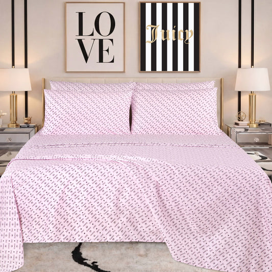 A neatly made bed with pink patterned bedding, featuring a Microfiber Sheet Set With Extra Pillowcases for added style, is flanked by two lamps on mirrored nightstands. Above the bed are two wall art pieces: one says LOVE and the other says Juicy on black and white stripes.