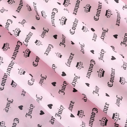 A close-up of pink microfiber fabric printed with black crowns, hearts, and the words "Juicy Couture" in a gothic font, arranged in various orientations—perfect for adding a playful touch to your bedding or as part of the Microfiber Sheet Set With Extra Pillowcases.