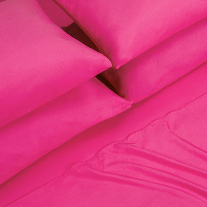 Four bright pink pillows are stacked next to each other on top of a matching pink Microfiber Sheet Set With Extra Pillowcases, showcasing a vibrant and colorful luxury bedding ensemble.