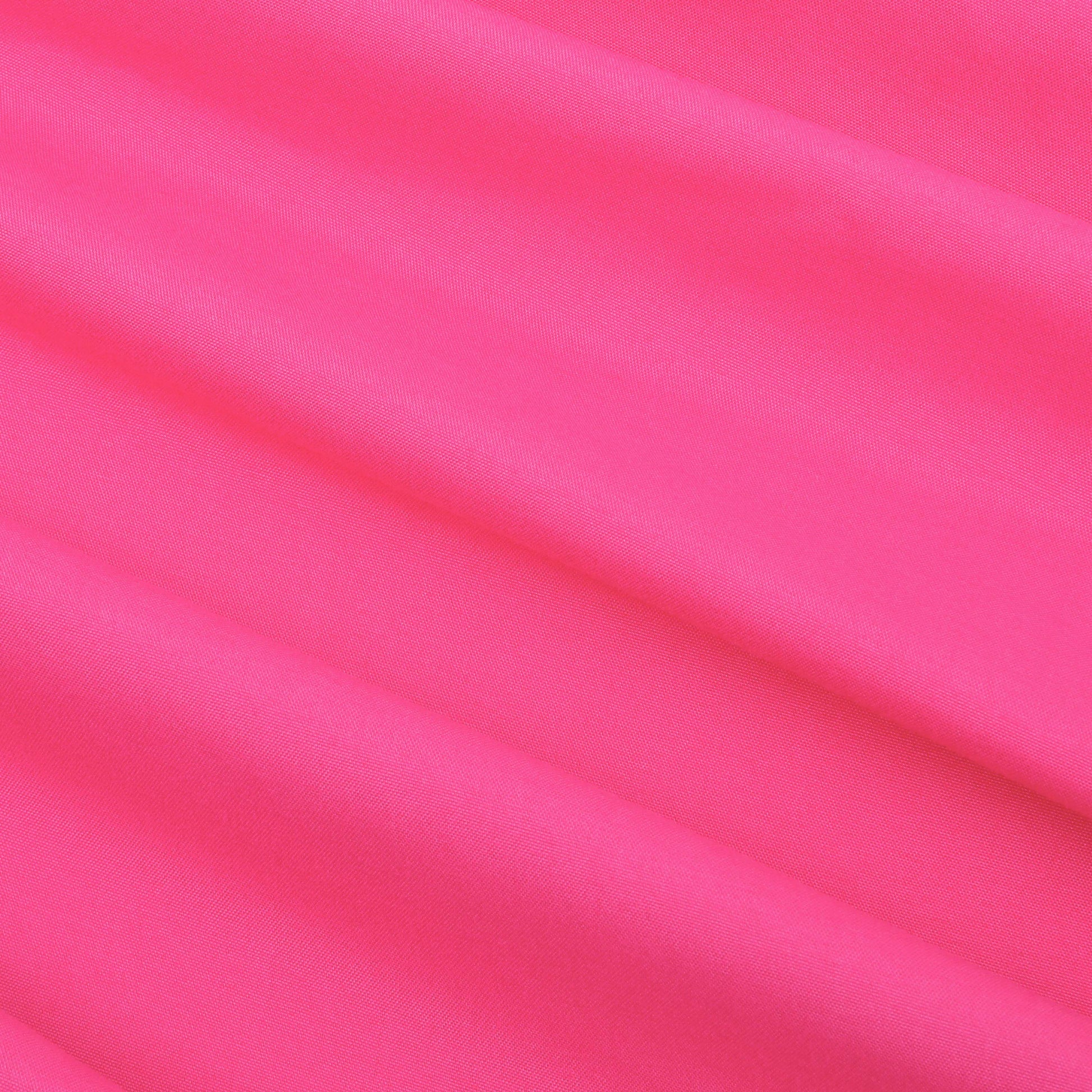 Experience the luxurious feel of our Microfiber Sheet Set With Extra Pillowcases, featuring bright pink fabric adorned with soft folds running diagonally across the surface—creating gentle shadows and a smooth texture reminiscent of luxury bedding.