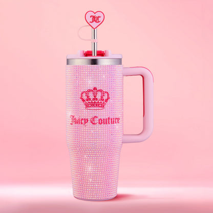 Introducing the Diamond Bling Stainless Steel Tumbler with Handle and Straw, 30 oz—a chic pink Juicy Couture tumbler adorned with dazzling rhinestones and the signature crown logo. This glamorous tumbler includes a convenient handle and a pink straw topped with a heart-shaped charm featuring the Juicy Couture JC initials. The matching soft pink background beautifully complements its stylish design.