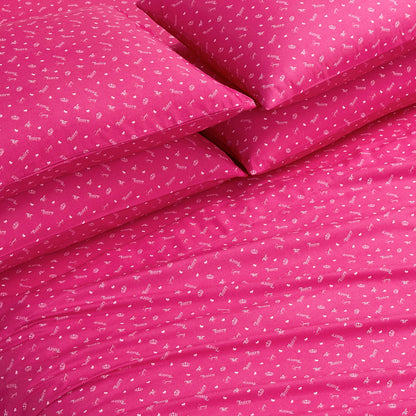 The Microfiber Sheet Set With Extra Pillowcases features bright pink bedding with playful white icons and words, arranged neatly on the bed. These ultra-soft sheets add a cheerful, inviting touch to any room.