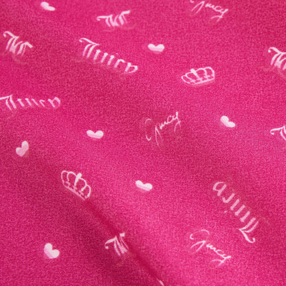 The Microfiber Sheet Set With Extra Pillowcases features bright pink bedding with white crowns, small hearts, and "Juicy" in cursive, adding a stylish and cozy touch to any room.