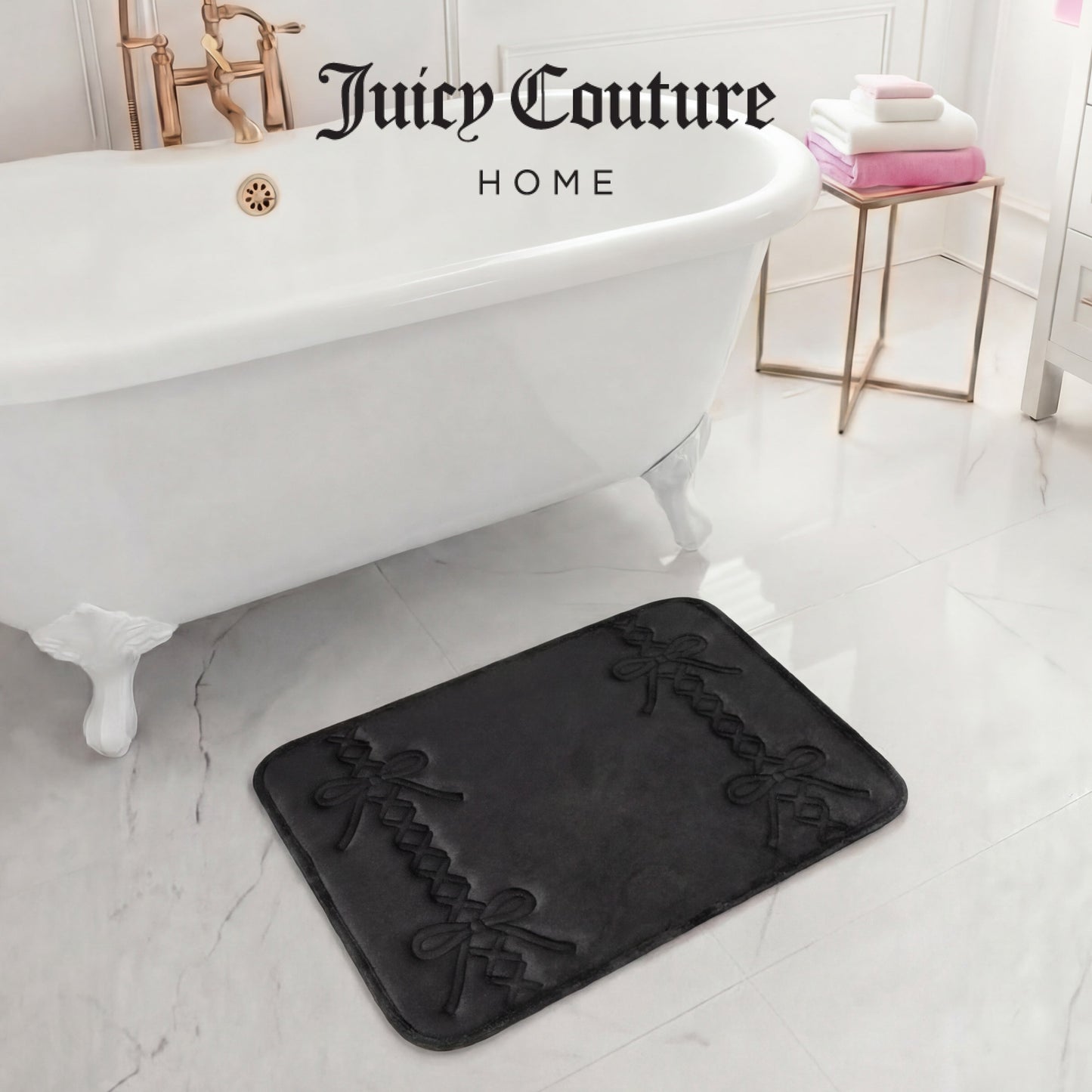 A luxurious bathroom features a white clawfoot tub, gold fixtures, and a 17" x 24" Quilted Memory Foam Bath Mat with black bows. Stacked white and pink towels add elegance, and "Juicy Couture Home" is displayed above the tub.