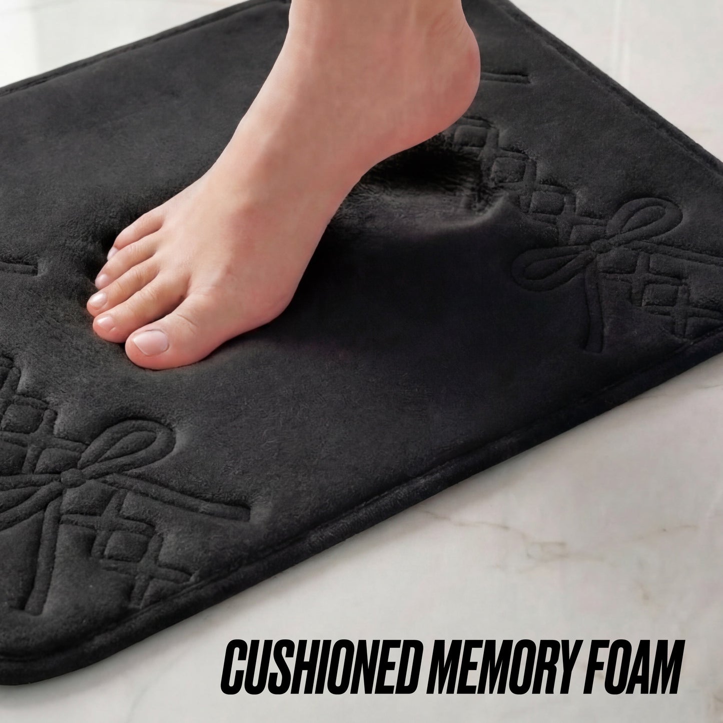 A bare foot steps onto the Quilted Memory Foam Bath Mat, 17" x 24", with decorative patterns, on a light floor. The text CUSHIONED MEMORY FOAM appears at the bottom.