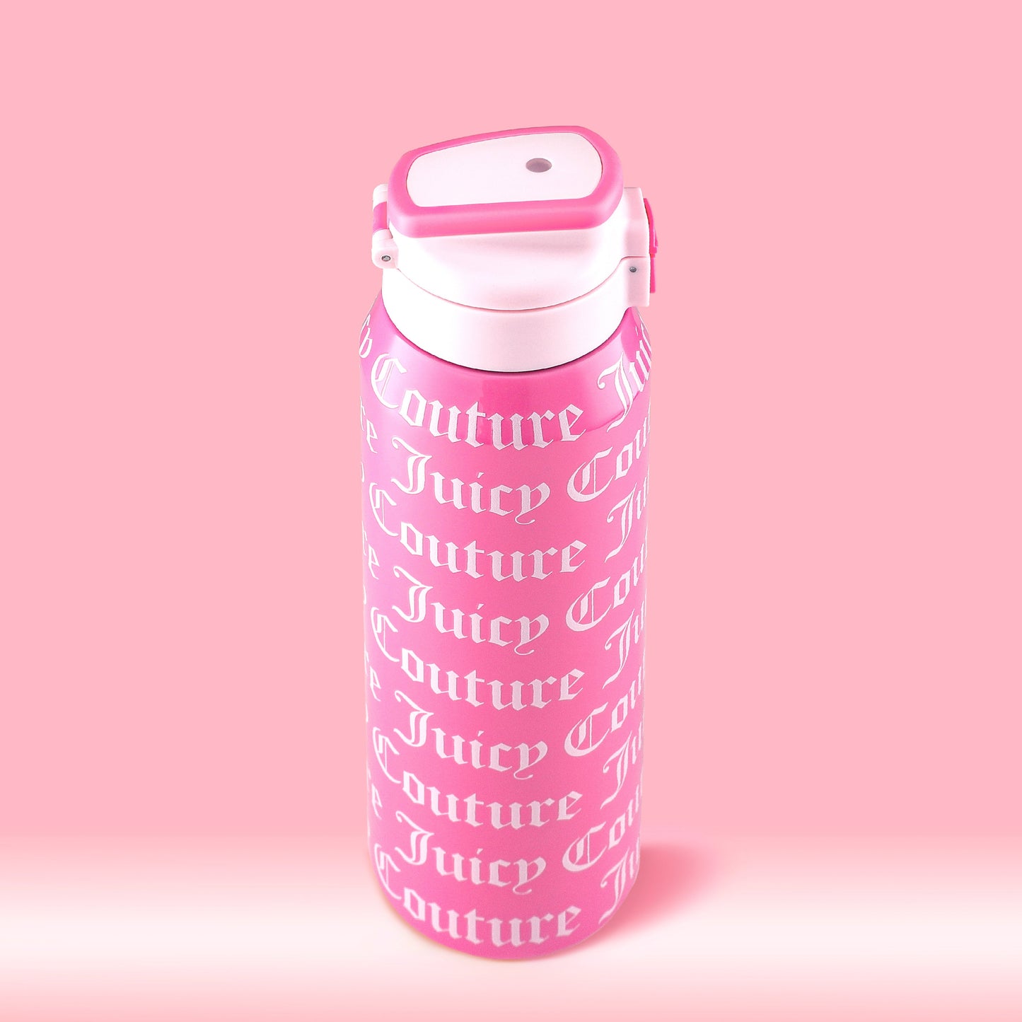The Glam Getaway Hydration Stainless Steel Tumbler is pink with a white flip-top lid and "Juicy Couture" printed in white cursive. This 32oz tumbler combines style and practicality for everyday hydration.