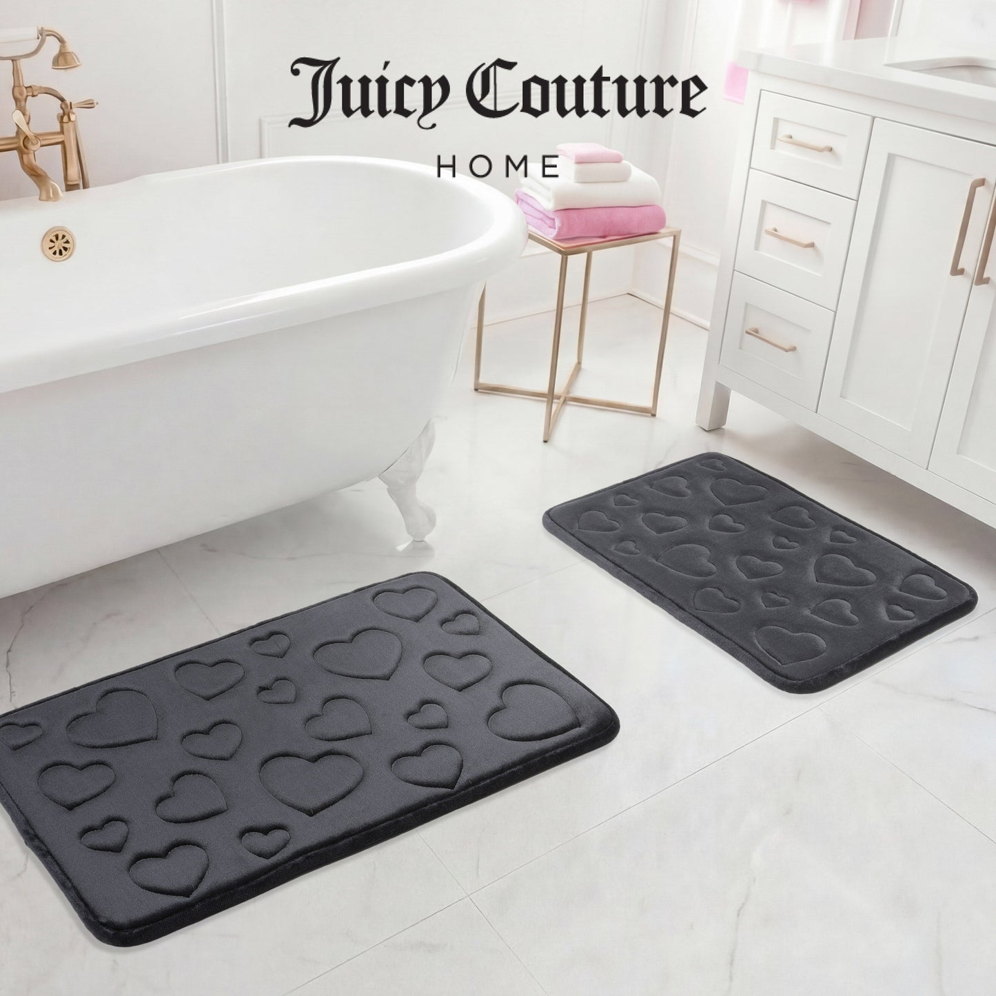 The image shows two black Quilted Memory Foam Bath Mats (2-piece set) adding style to a white bathroom floor by the tub, vanity, and towels. "Juicy Couture Home" appears at the top of the image.