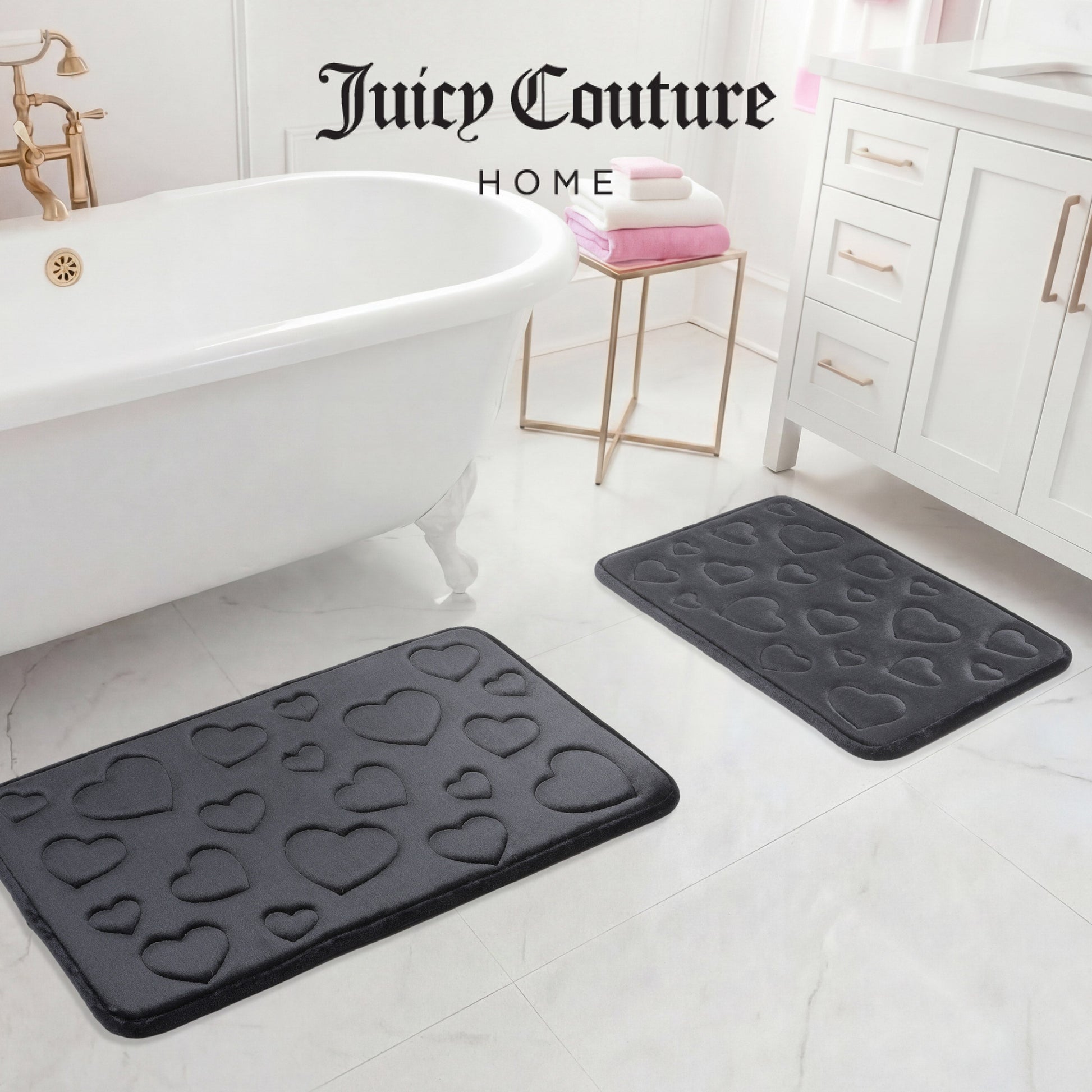 The image shows two black Quilted Memory Foam Bath Mats (2-piece set) adding style to a white bathroom floor by the tub, vanity, and towels. "Juicy Couture Home" appears at the top of the image.