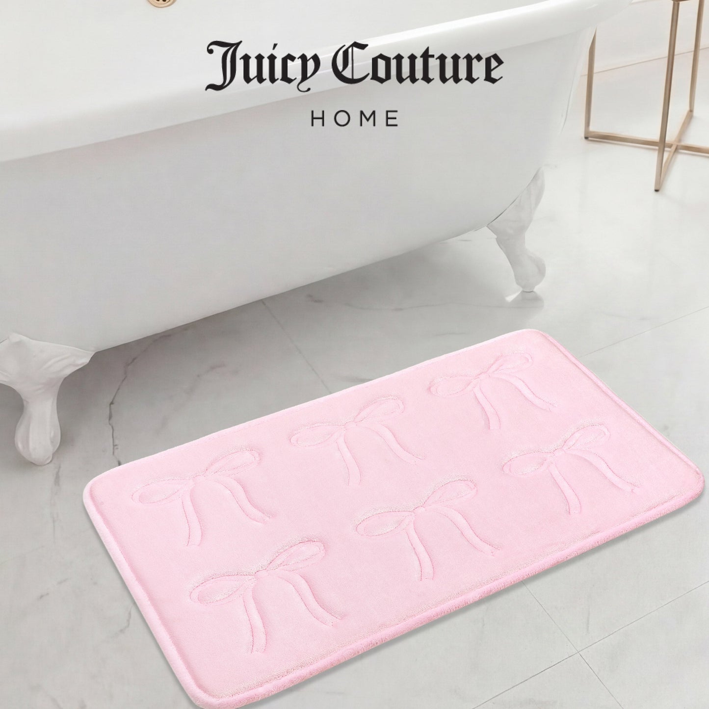 A Quilted Memory Foam Bath Mat (20" x 32") in light pink, featuring embossed bows, rests on a marble bathroom floor near a white clawfoot tub. "Juicy Couture Home" is elegantly displayed above the mat.