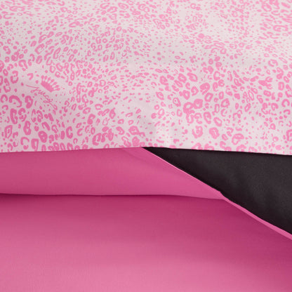 Close-up of the In The Wild Solid Reversible Bed in a Bag Bedding Set, featuring a pink leopard print comforter with black underside and solid pink sheet set.