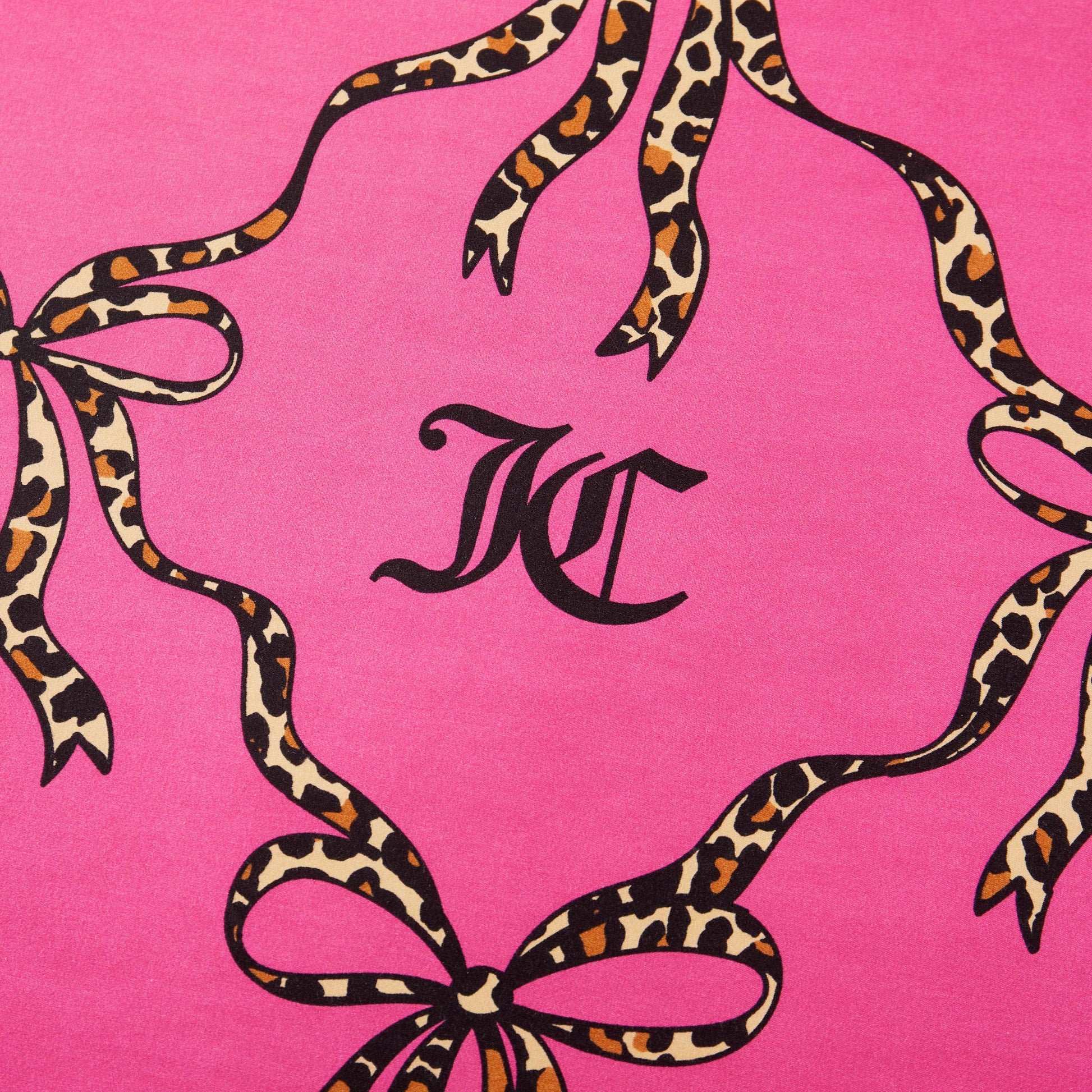 The Cheetah Bow Trellis Reversible Comforter Set features black “KC” initials on a pink background, framed by leopard-print ribbons and bows for a fashion-inspired look that elevates your space.