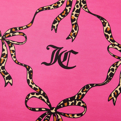 The Cheetah Bow Trellis Reversible Comforter Set features black “KC” initials on a pink background, framed by leopard-print ribbons and bows for a fashion-inspired look that elevates your space.
