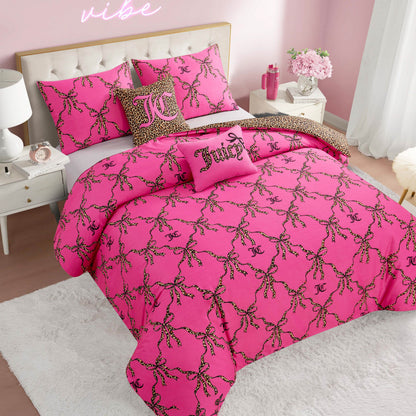 A pink bedroom features a bed with the Cheetah Bow Trellis Reversible Comforter Set and pillows adorned with cheetah-print chains, JC and Juicy logos. The room has white furniture, pink walls, and a "vibe" neon sign for a fashion-inspired look.