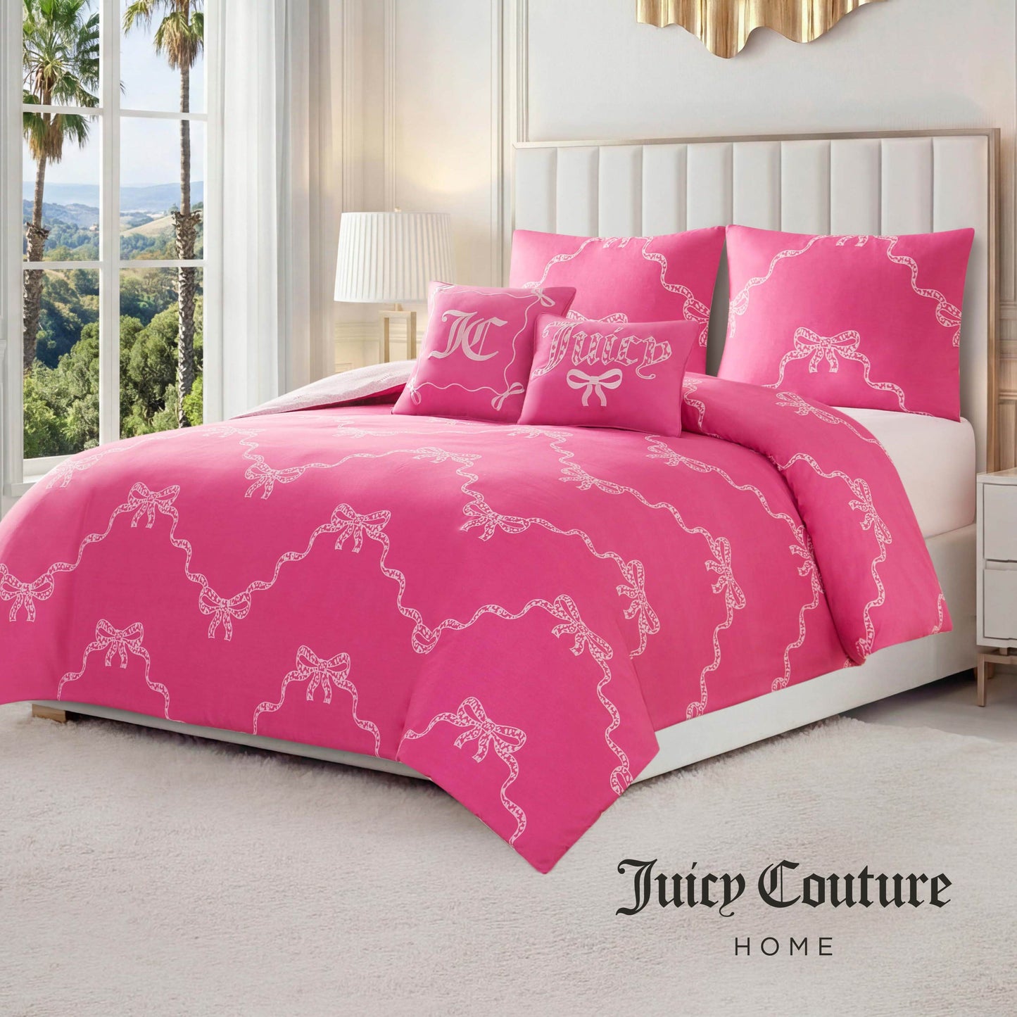 A neatly made bed with a bright pink Chevron Leopard Bow Reversible Comforter Set featuring white bow patterns, matching embroidered pillows, and a white tufted headboard in a sunlit bedroom with large windows and palm trees outside.