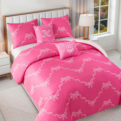 A neatly made bed features an embroidered decorative pillow and the Chevron Leopard Bow Reversible Comforter Set, in a bright bedroom with white walls, a bedside lamp, and a window letting in abundant natural light.