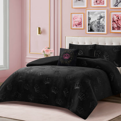A neatly made bed with glamorous bedding, featuring the Embossed Plush Crown Comforter Set from Juicy Couture and a Juicy Couture crown pillow, stands out against pink walls adorned with framed floral and city photos. A vase of pink roses on the nightstand adds an extra touch of elegance.