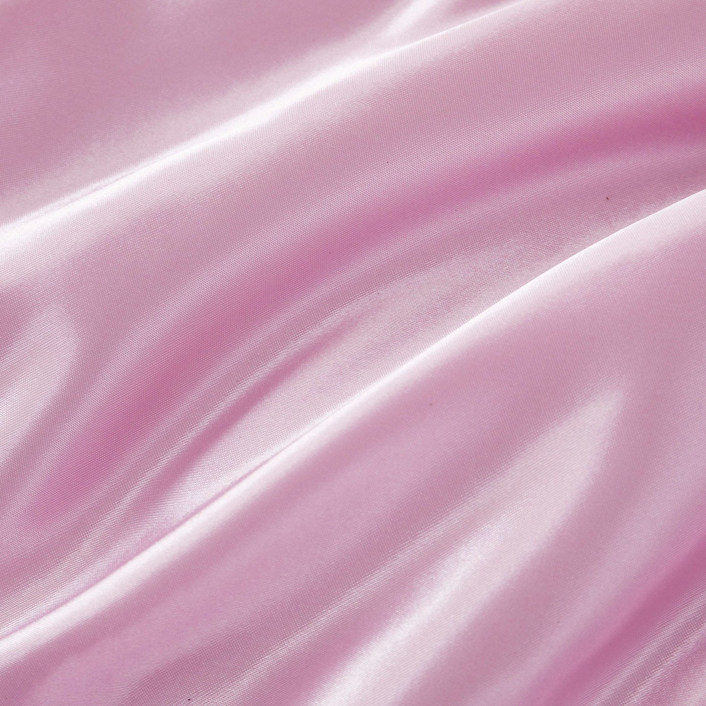 Experience a luxurious look and feel with the Solid Satin Down Alternative Comforter—crafted from shiny, light pink satin fabric featuring soft folds, a smooth texture, and gentle highlights that reflect light, this comforter delivers all-season warmth with an elegant touch.