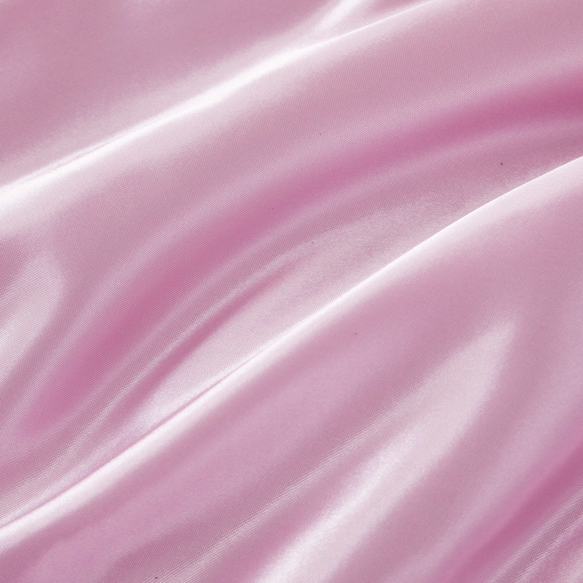 Experience a luxurious look and feel with the Solid Satin Down Alternative Comforter—crafted from shiny, light pink satin fabric featuring soft folds, a smooth texture, and gentle highlights that reflect light, this comforter delivers all-season warmth with an elegant touch.