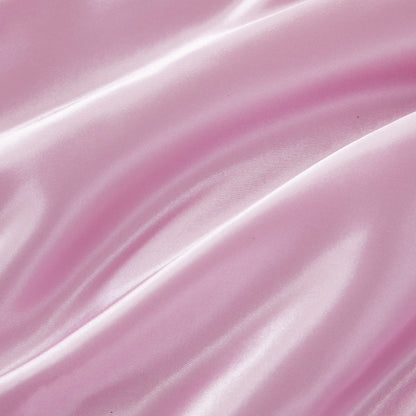 Experience a luxurious look and feel with the Solid Satin Down Alternative Comforter—crafted from shiny, light pink satin fabric featuring soft folds, a smooth texture, and gentle highlights that reflect light, this comforter delivers all-season warmth with an elegant touch.