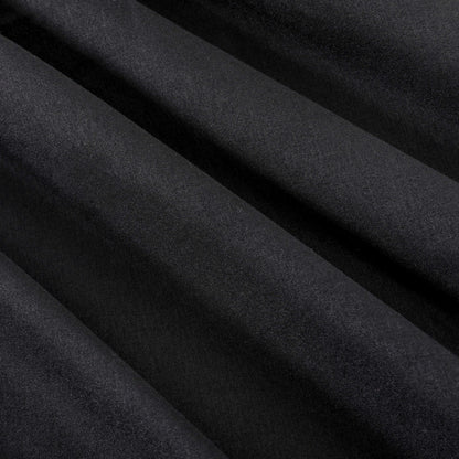 Close-up of smooth, black fabric with diagonal folds creating soft shadows and highlights across the surface, evoking the elegance of a luxury bedding collection such as the Microfiber Sheet Set With Extra Pillowcases.