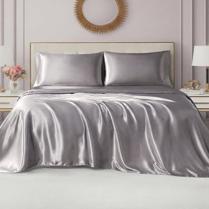 A modern bedroom features a neatly made bed with the Solid Satin Sheet Set, ultra-soft sheets and pillowcases, a cream headboard, white nightstands, gold accents, and a round mirror above the bed.