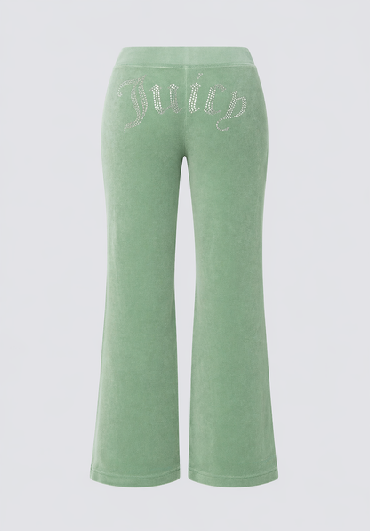 Big Bling Washed Terry Track Pants in light green feature flared legs and a sparkling rhinestone "Juicy" logo across the back, combining comfort with iconic flair. Displayed on a plain white background.