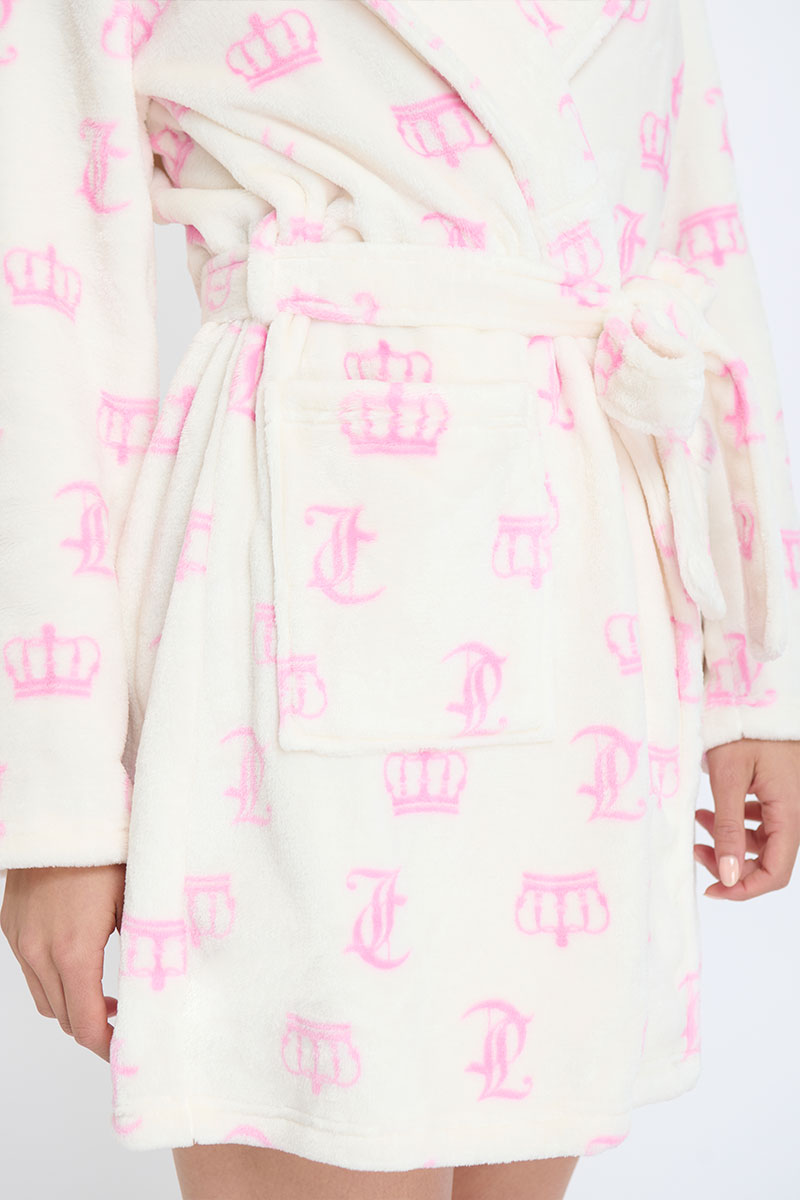 Wearing the Hooded Luxe Plush Robe in cream with pink crown and J designs, a person rests their hand by the pocket. The ultra-cozy robe features a hood, waist tie belt, and convenient pocket.